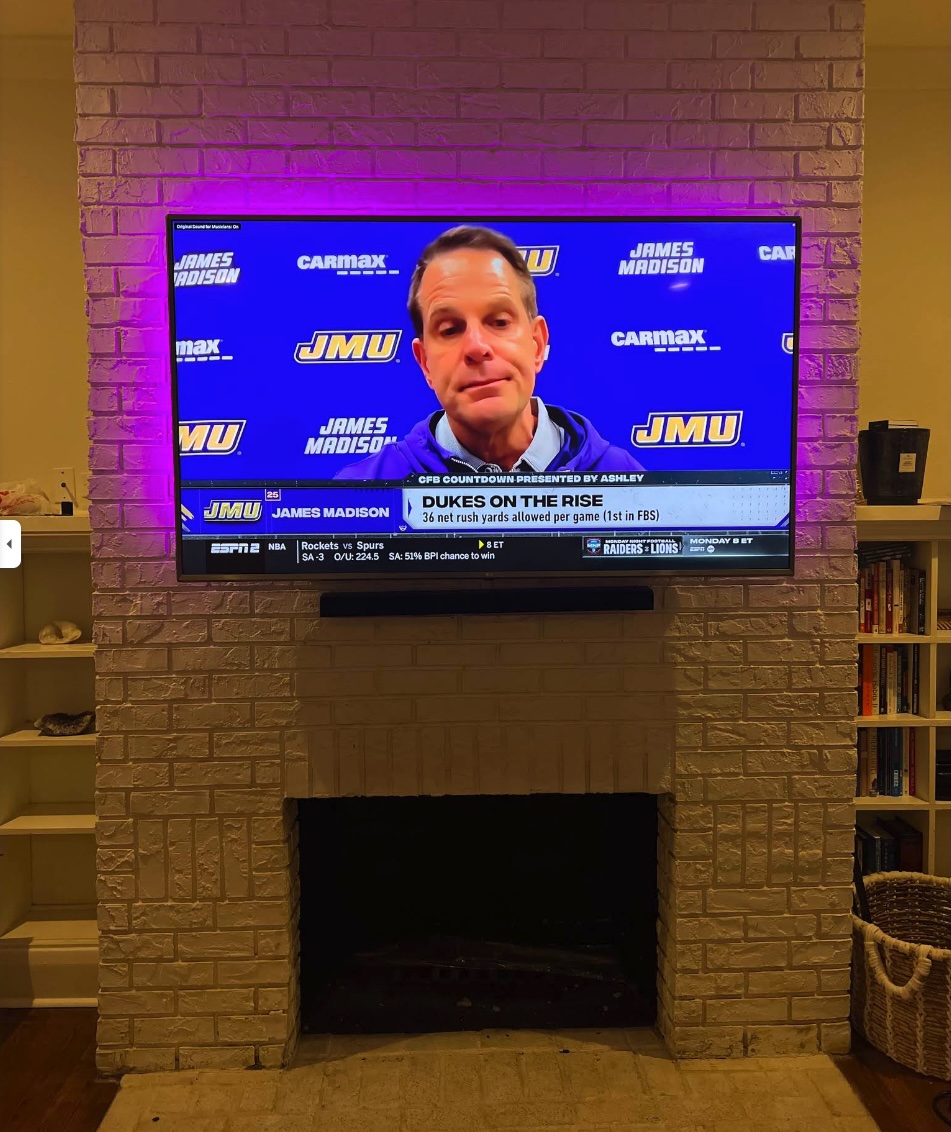 TV mounted above brick fireplace with purple LED backlighting — Quality Handyman Services Tampa